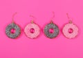 Four glasses donuts on pink background. Christmas toy: chocolate and pink donats. Merry Christmas and Happy New Year concept. Royalty Free Stock Photo