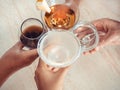 Four glasses of drinks in the hands of people