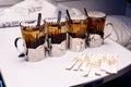 Four glasses with tea in metal holders on table at the train.