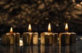 Four golden advent candles lit with bokeh background