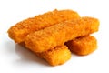 Four golden fried fish fingers stacked on white