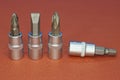 Four gray metal bits for a screwdriver
