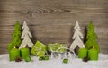 Four green burning christmas candles with presents and trees on Royalty Free Stock Photo