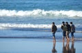 Four guys walking on the beach