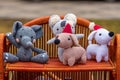 Four handmade knitted toys on wicker shelf