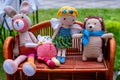 Four handmade knitted toys on wicker shelf