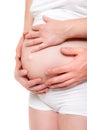 Four hands holding belly of a pregnant woman Royalty Free Stock Photo