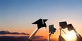 Four hands holding graduation hats