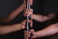 Four hands holding a pole dance bar