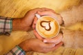 Four hands wrapped around a cup of coffee Royalty Free Stock Photo