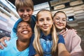 Four happy adolescent boys and girls taking selfie outdoors