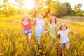 Four happy beautiful children running playing moving together in the beautiful summer day. Royalty Free Stock Photo