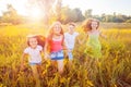 Four happy beautiful children running playing moving together in the beautiful summer day. Royalty Free Stock Photo