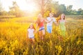 Four happy beautiful children running playing moving together in the beautiful summer day. Royalty Free Stock Photo