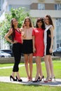 Four happy cute women pose outdoor on street at