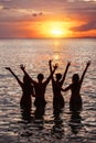 Four happy friends having fun at sunset beach Royalty Free Stock Photo