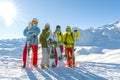 Four happy friends snowboarders and skiers are having fun on ski slope with ski and snowboards in sunny day Royalty Free Stock Photo