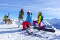 Four happy friends snowboarders and skiers are having fun on ski slope with ski and snowboards in sunny day Royalty Free Stock Photo