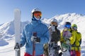 Four happy friends snowboarders and skiers are having fun on ski slope with ski and snowboards in sunny day. Royalty Free Stock Photo