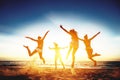 Four happy girls run and jump against sunset sea Royalty Free Stock Photo