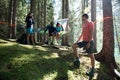 Four happy man and woman hanging tent camping in forest woods during sunny day near lake.Group of friends people summer Royalty Free Stock Photo