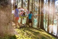 Four happy man and woman hanging tent camping in forest woods during sunny day near lake.Group of friends people summer Royalty Free Stock Photo