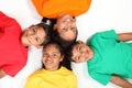 Four happy school friends lying on floor together