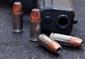 Four hollow point bullets with a black pistol Royalty Free Stock Photo