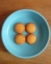 Four homemade biscuits on a blue plastic plate.