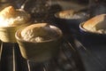 Four homemade gorgonzola soufflÃÂ©s, seen through the glass of the home oven.