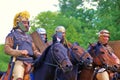 Four horse riders. Green trees foliage background.