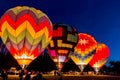 Four hot air balloons are launching at dawn.