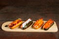 Four hot dogs on wooden chopping board. Royalty Free Stock Photo