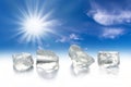 Four ice cubes, sun and blue sky Royalty Free Stock Photo