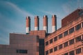 four industrial chimneys on top of a modern building