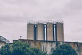 Four industrial metal storage tanks above a wall