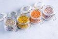 Four jars with different flavoured mixes of salt and spices. Himalayan and sea salt mixed with various peppers and herbs