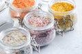 Four jars with different flavoured mixes of salt and spices. Himalayan and sea salt mixed with various peppers and herbs