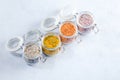 Four jars with different flavoured mixes of salt and spices. Himalayan and sea salt mixed with various peppers and herbs