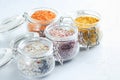 Four jars with different flavoured mixes of salt and spices. Himalayan and sea salt mixed with various peppers and herbs