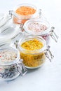 Four jars with different flavoured mixes of salt and spices. Himalayan and sea salt mixed with various peppers and herbs