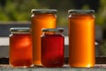 Four jars of honey, two large and two small, on a hive