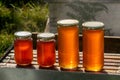 Four jars of honey, two large and two small, on a hive