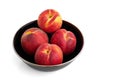 Four juicy peaches in a black bowl Royalty Free Stock Photo