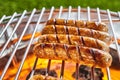 Four juicy pork sausages grilling on a BBQ Royalty Free Stock Photo