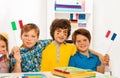 Four kids with banners on cheeks waving flags