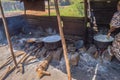 Four large saucepans resting on log fires