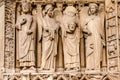 The four large statues of the left-hand side of the portal of the Virgin represent an unidentified king and Saint Denis
