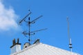 Four large TV antennas put over satellite dish mounted on metal pole on top of office building new metal roof Royalty Free Stock Photo