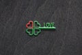 Four-leaf green clover shaped key with red heart as symbol of love and good luck concept